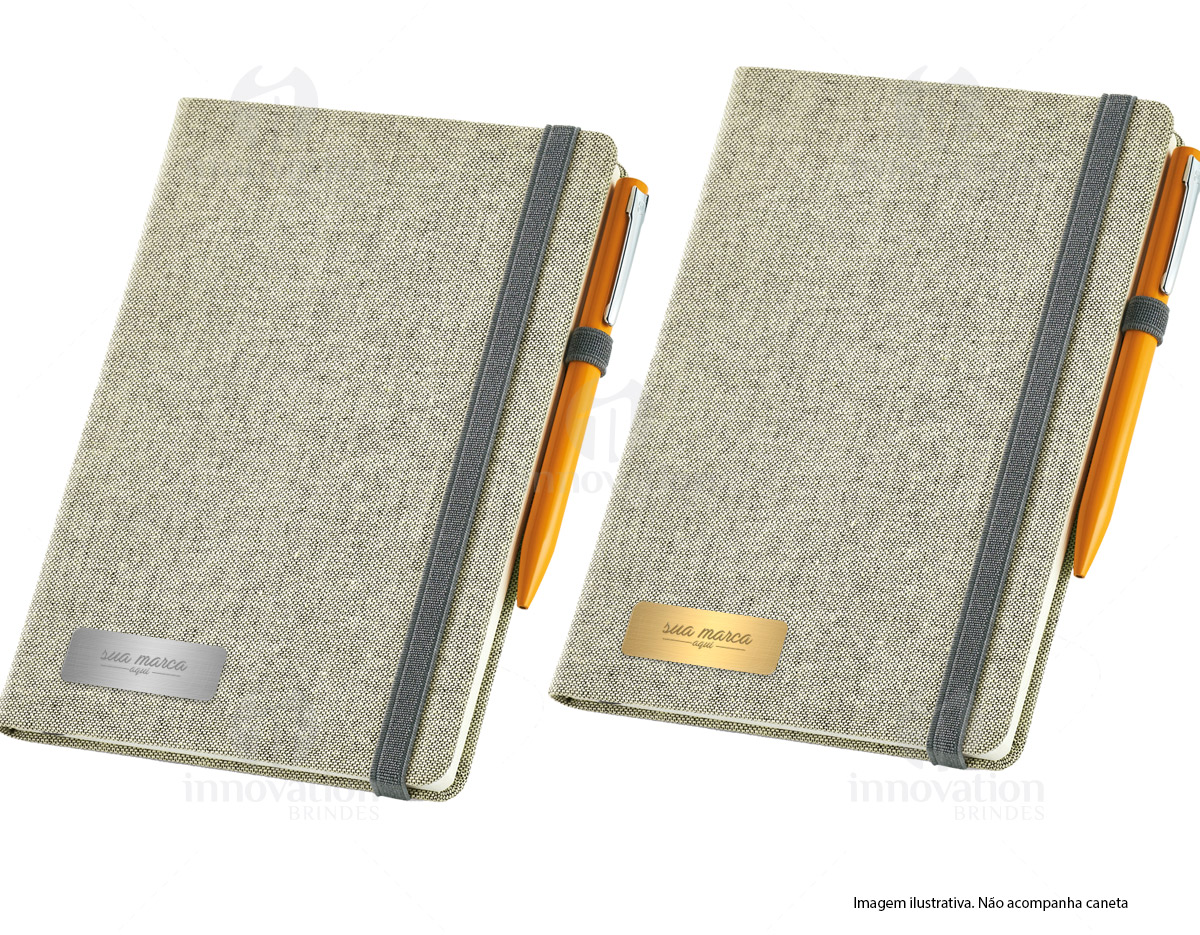 Caderno capa dura com porta esferográfica e folhas não pautadas cor marfim. Fornecido em embalagem de non-woven. Esferográfica não inclusa.