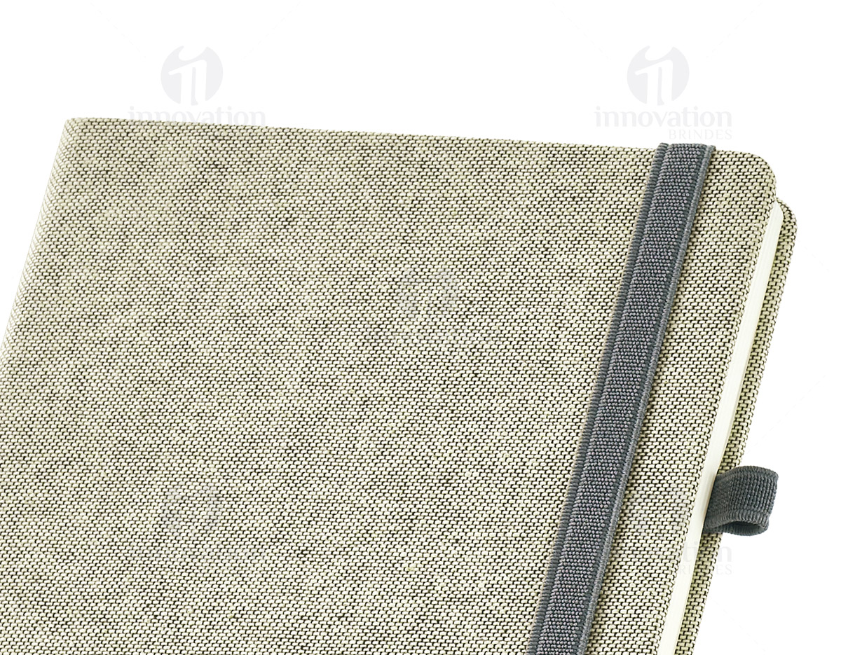 Caderno capa dura com porta esferográfica e folhas não pautadas cor marfim. Fornecido em embalagem de non-woven. Esferográfica não inclusa.