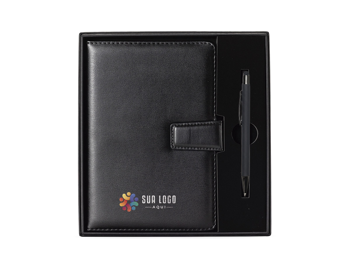 Kit executivo com duas peças, composto por uma caderneta de capa em couro sintético com fechamento magnético e cerca de 80 folhas pautadas, e uma caneta em metal com detalhes em plástico, ponteira emborrachada para uso em dispositivos touchscreen e carga esferográfica azul de 1,0 mm. Acompanha uma caixa de papelão com berço em espuma para a caneta.
