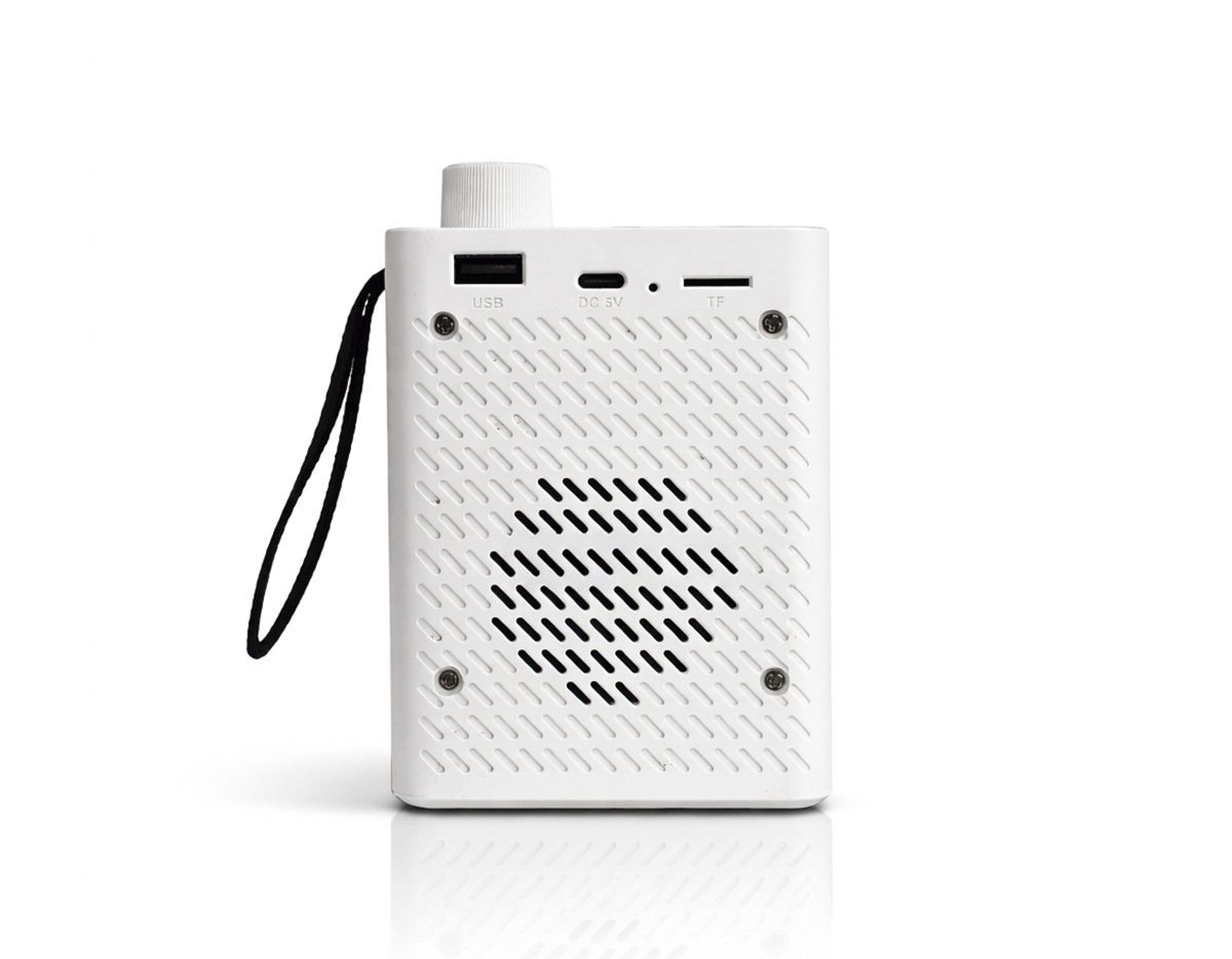 Caixa de som multimídia com estrutura em plástico e iluminação RGB ajustável na parte frontal. Possui conexão Bluetooth 5.4 e rádio FM, além de entradas USB-A e TF (microSD) para a reprodução de arquivos MP3 via pen drives e cartões microSD. Conta ainda com painel de botões na parte superior, base antiderrapante, alça lateral em nylon e entrada USB-C para carregamento do aparelho. Acompanha cabo USB-C.