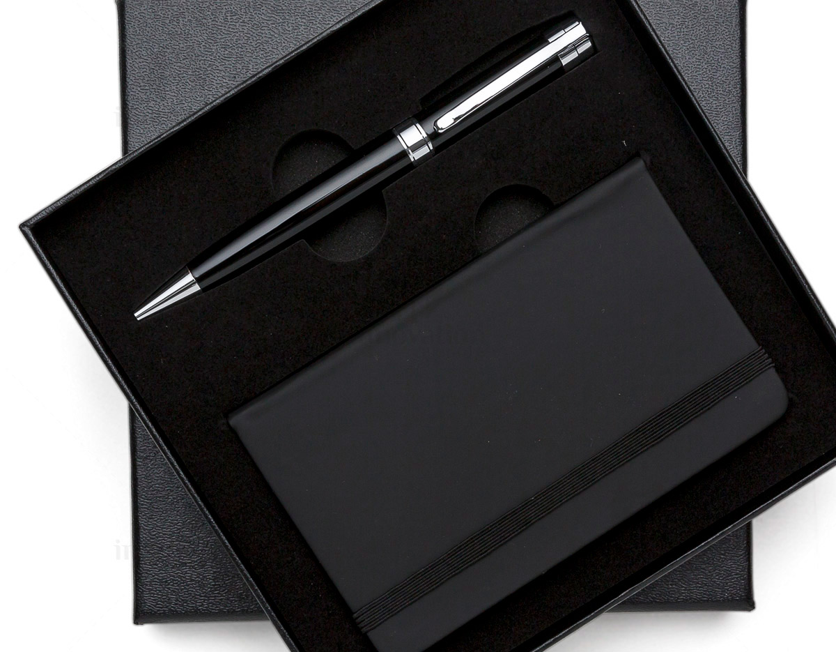 Kit executivo 2 peças. Acompanha: caneta metal preta com anel, detalhes em prata e escrita preta e caderneta tipo moleskine em couro sintético com aproximadamente 80 folhas amarelas pautadas.