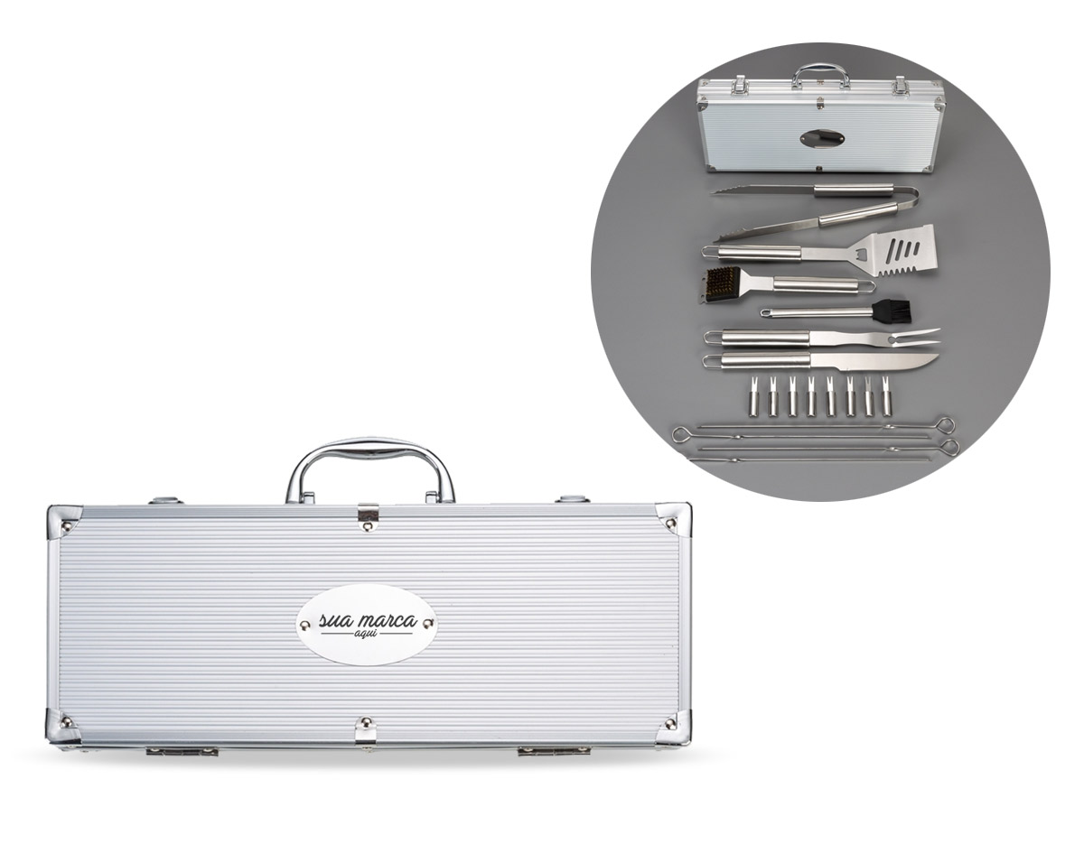 Kit churrasco 18 peças em maleta de alumínio com relevo e placa central para personalização. Possui: garfo, espátula, pegador, faca, escova, pincel, 4 espetos e pegadores de petisco. Detalhes em metal nas bordas da maleta, duas dobradiças na parte inferior, uma alça e duas presilhas para travar/abrir maleta. Parte interna revestida de tecido tnt e velcro para guardar as peças.