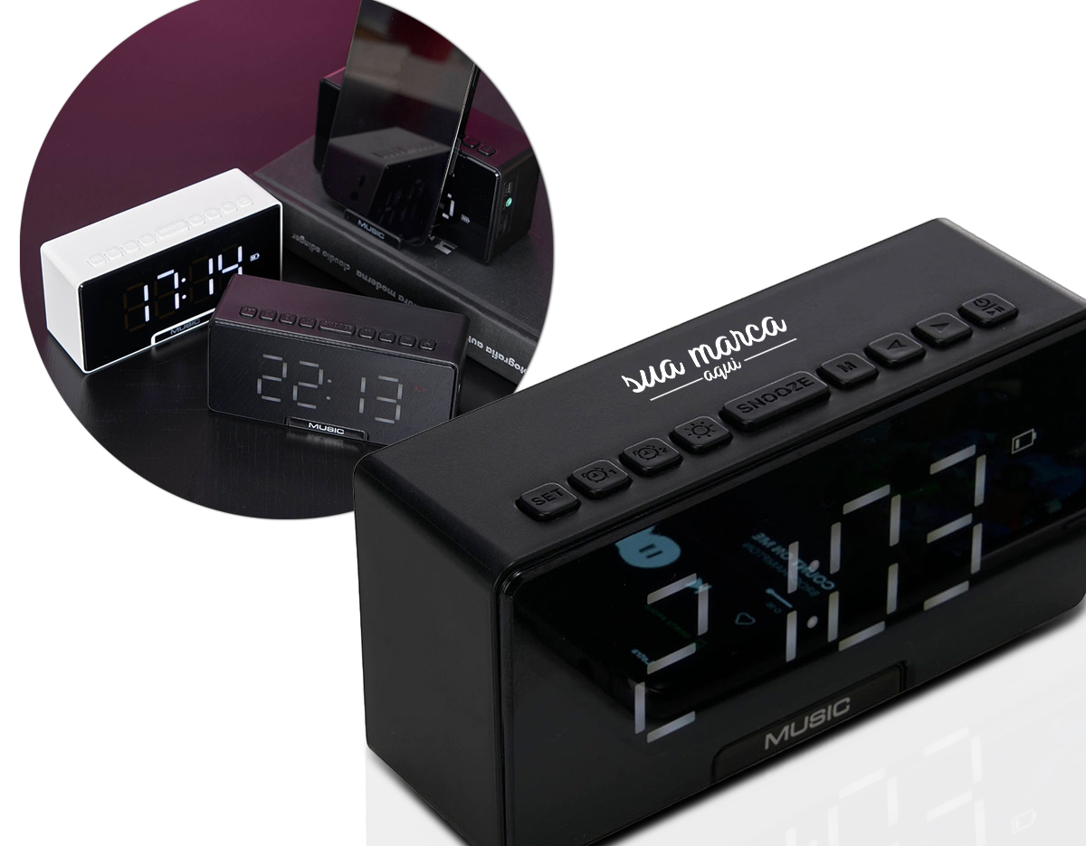 Caixa de som multimídia com relógio despertador e suporte para celular. Produzida em plástico e com borrachas antiderrapantes na área inferior, a caixa de som tem a área frontal com display de LED, além de um compartimento com suporte para celular – uma espécie de "gaveta" aonde é exibido (MUSIC), basta puxá-la ter acesso ao compartimento. A caixa de som executa nos modos bluetooth, rádio FM, cartão TF-microSD e entrada auxiliar P2. Acompanha cabo USB e manual em inglês.
