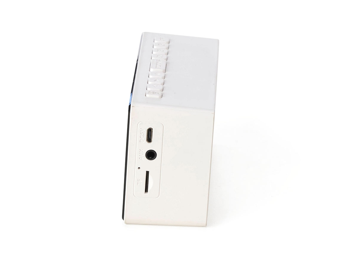 Caixa de som multimídia com relógio despertador e suporte para celular. Produzida em plástico e com borrachas antiderrapantes na área inferior, a caixa de som tem a área frontal com display de LED, além de um compartimento com suporte para celular – uma espécie de "gaveta" aonde é exibido (MUSIC), basta puxá-la ter acesso ao compartimento. A caixa de som executa nos modos bluetooth, rádio FM, cartão TF-microSD e entrada auxiliar P2. Acompanha cabo USB e manual em inglês.