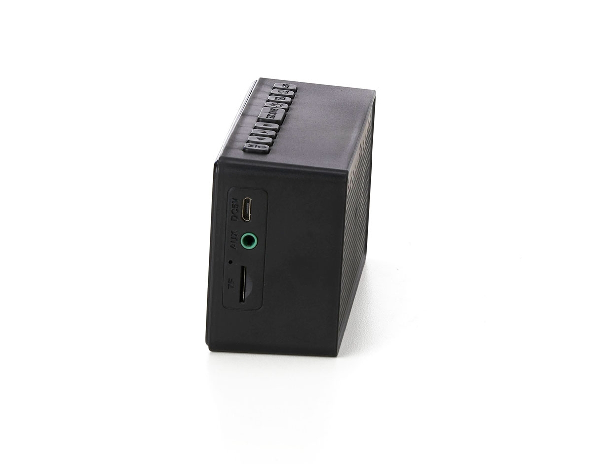 Caixa de som multimídia com relógio despertador e suporte para celular. Produzida em plástico e com borrachas antiderrapantes na área inferior, a caixa de som tem a área frontal com display de LED, além de um compartimento com suporte para celular – uma espécie de "gaveta" aonde é exibido (MUSIC), basta puxá-la ter acesso ao compartimento. A caixa de som executa nos modos bluetooth, rádio FM, cartão TF-microSD e entrada auxiliar P2. Acompanha cabo USB e manual em inglês.