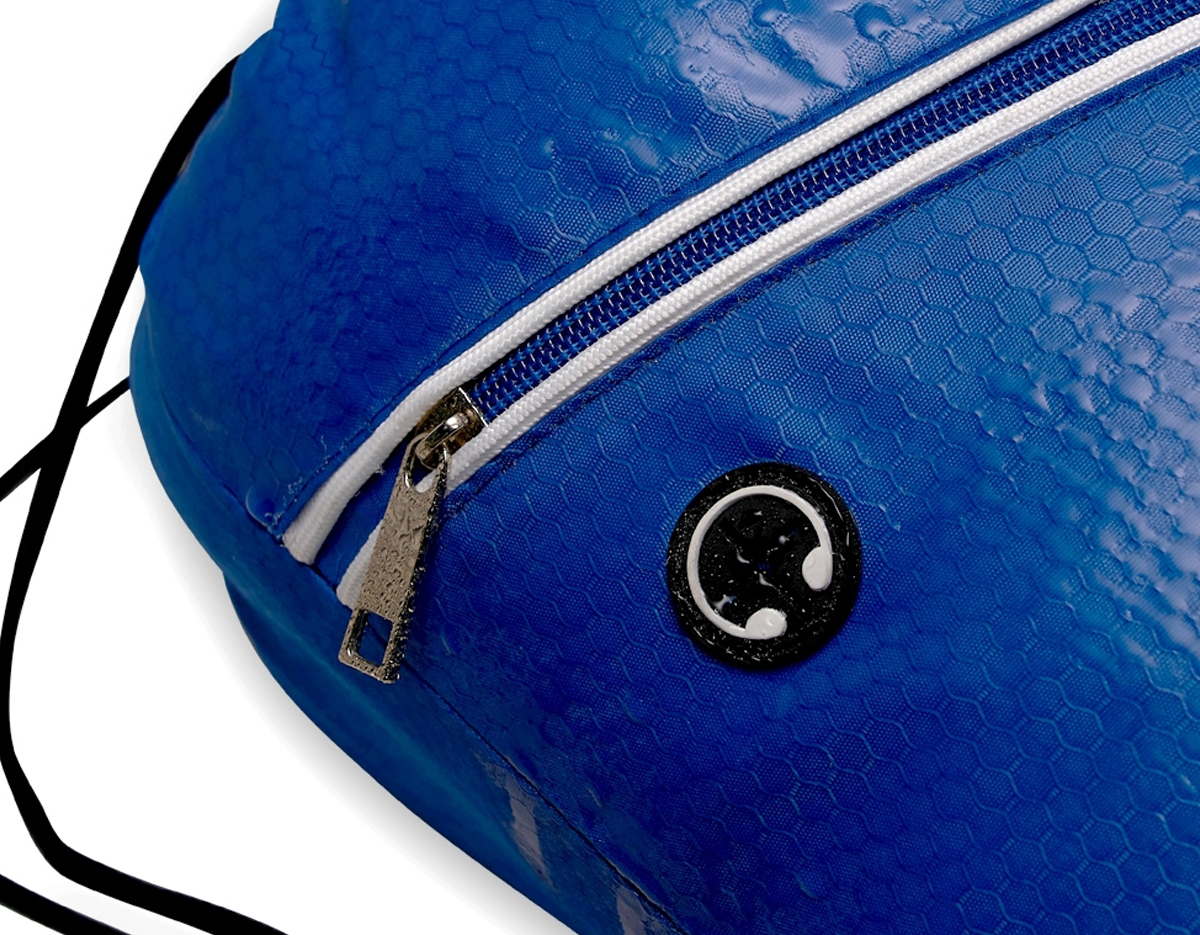 Mochila saco impermeável em fibra de poliéster. Contém bolso diagonal na parte frontal com entrada para fones de ouvido e alças de nylon.