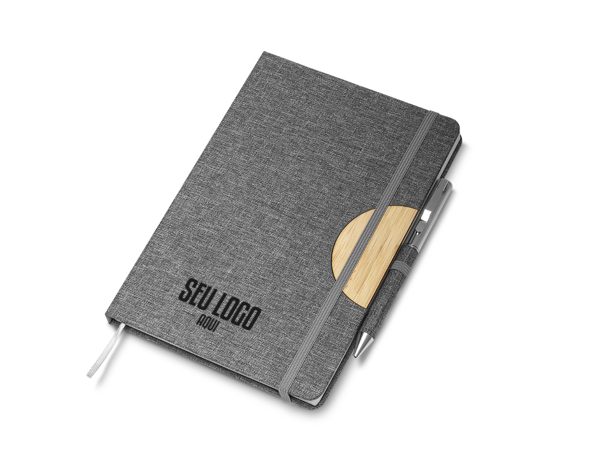 Caderno de anotações com suporte para caneta, fechamento com elástico, capa dura em material reciclável, suporte para celular na capa e miolo com 80 folhas pautadas na cor bege. NÃO ACOMPANHA CANETA.
