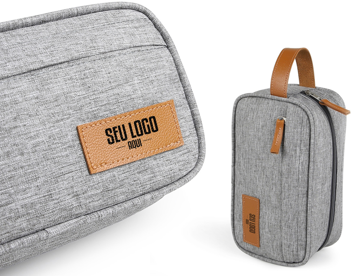 Nécessaire confeccionada em poliéster com elegantes detalhes em couro sintético, unindo resistência e acabamento sofisticado. Possui dois compartimentos com fechamento em zíper, que facilitam a organização de itens pessoais de forma prática e segura. Conta com alça para transporte, proporcionando comodidade no uso diário, além de alça pequena ideal para fixação de chaveiro ou gancho. Versátil e funcional, é uma excelente opção de brinde corporativo, agregando utilidade, organização e destaque para a marca.