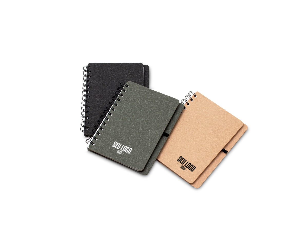 Caderneta B6 capa dura em kraft com wire-o e porta caneta. Contém aproximadamente 70 páginas pautadas na cor branca.