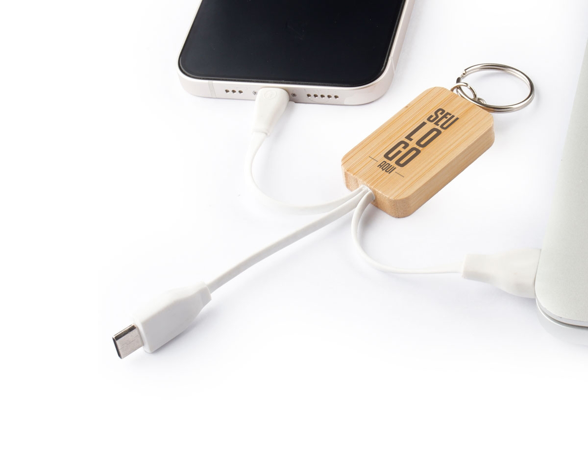 Chaveiro de bambu com cabo embutido para carregamento. Este modelo possui entradas USB, lightning e tipo C, compatível com a maioria dos dispositivos eletrônicos, trazendo assim, praticidade para quem precisa estar sempre conectado.