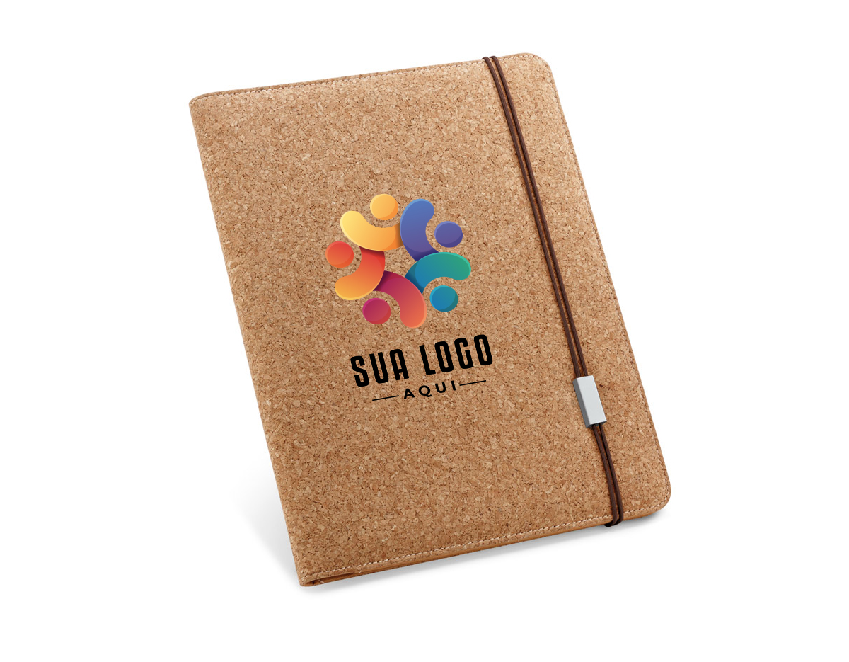 Pasta A4 em cortiça, com um bloco de 20 folhas lisas em cor marfim, suporte para esferográfica (não inclusa) e elástico. Fornecida em embalagem de non-woven. 239 x 307 x 17 mm | Bolsa: 285 x 350 mm