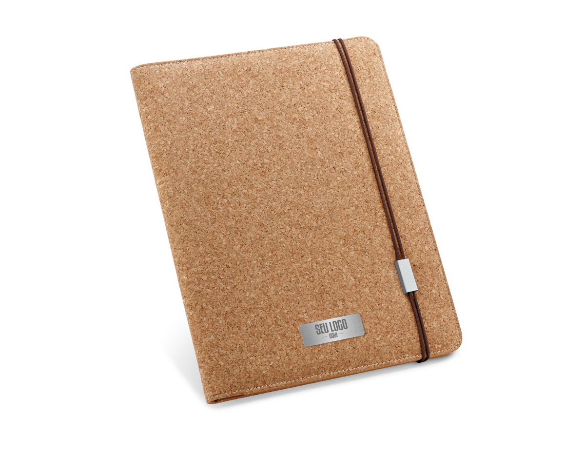 Pasta A4 em cortiça, com um bloco de 20 folhas lisas em cor marfim, suporte para esferográfica (não inclusa) e elástico. Fornecida em embalagem de non-woven. 239 x 307 x 17 mm | Bolsa: 285 x 350 mm