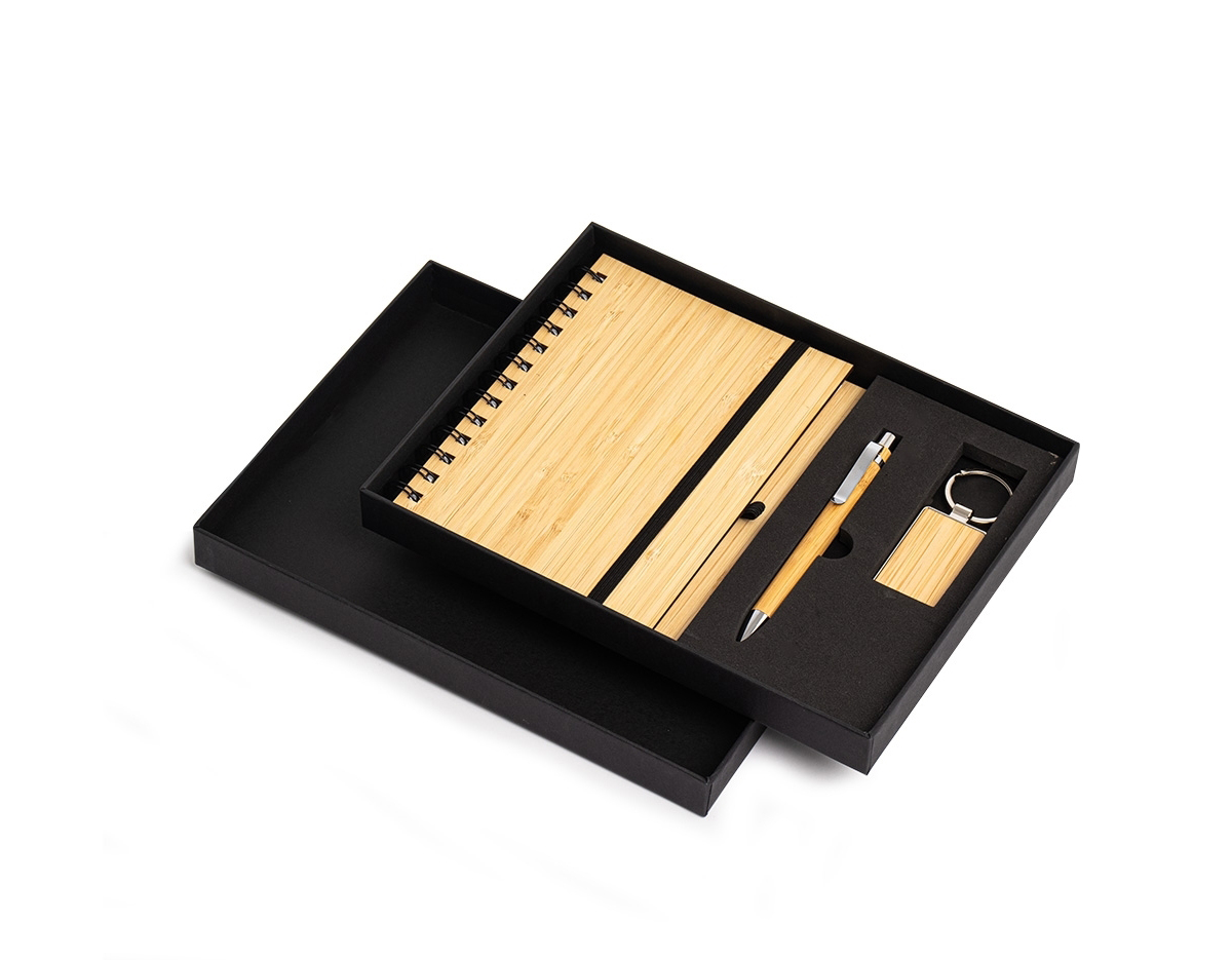 Kit executivo ecológico 3 peças em estojo de papelão. Contém: chaveiro de bambu com detalhe em metal, caderneta em bambu, capa dura, com aproximadamente 65 folhas brancas pautadas, caneta de bambu com clipe metálico, elástico para lacre e suporte para caneta em nylon.