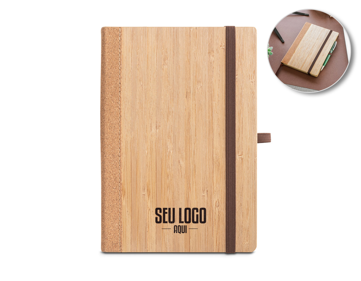 Caderno A5 de capa dura em folha de bambu e cortiça. Contém 80 folhas, em papel reciclado, pautadas cor de marfim, fita separadora, suporte para esferográfica (não inclusa) e elástico para fecho do caderno. A cor e o resultado da impressão nos materiais naturais pode variar entre produtos. 140 x 210 mm