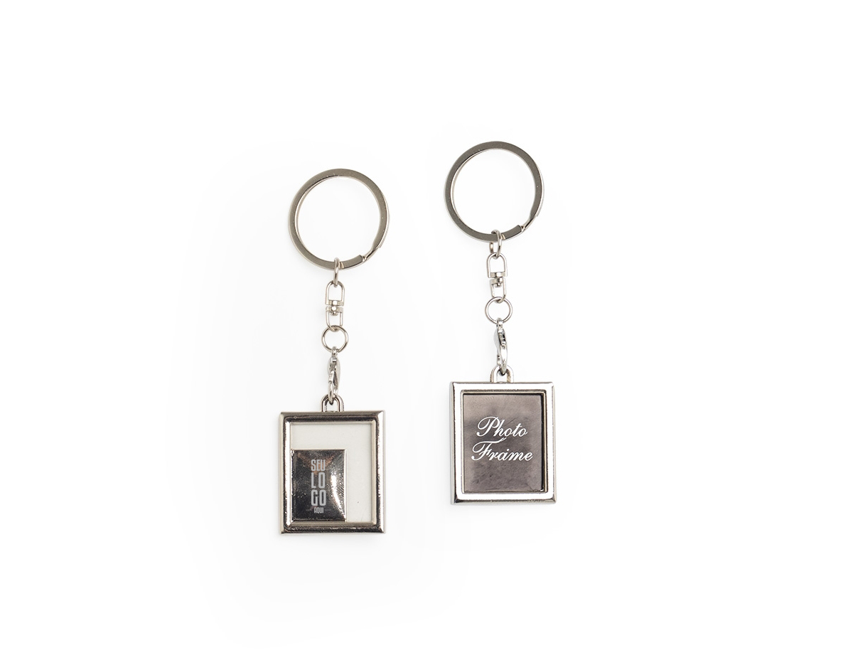 Chaveiro porta-foto em inox. Possui uma fina capa transparente removível para proteger a foto e corrente com gancho preto ao chaveiro.