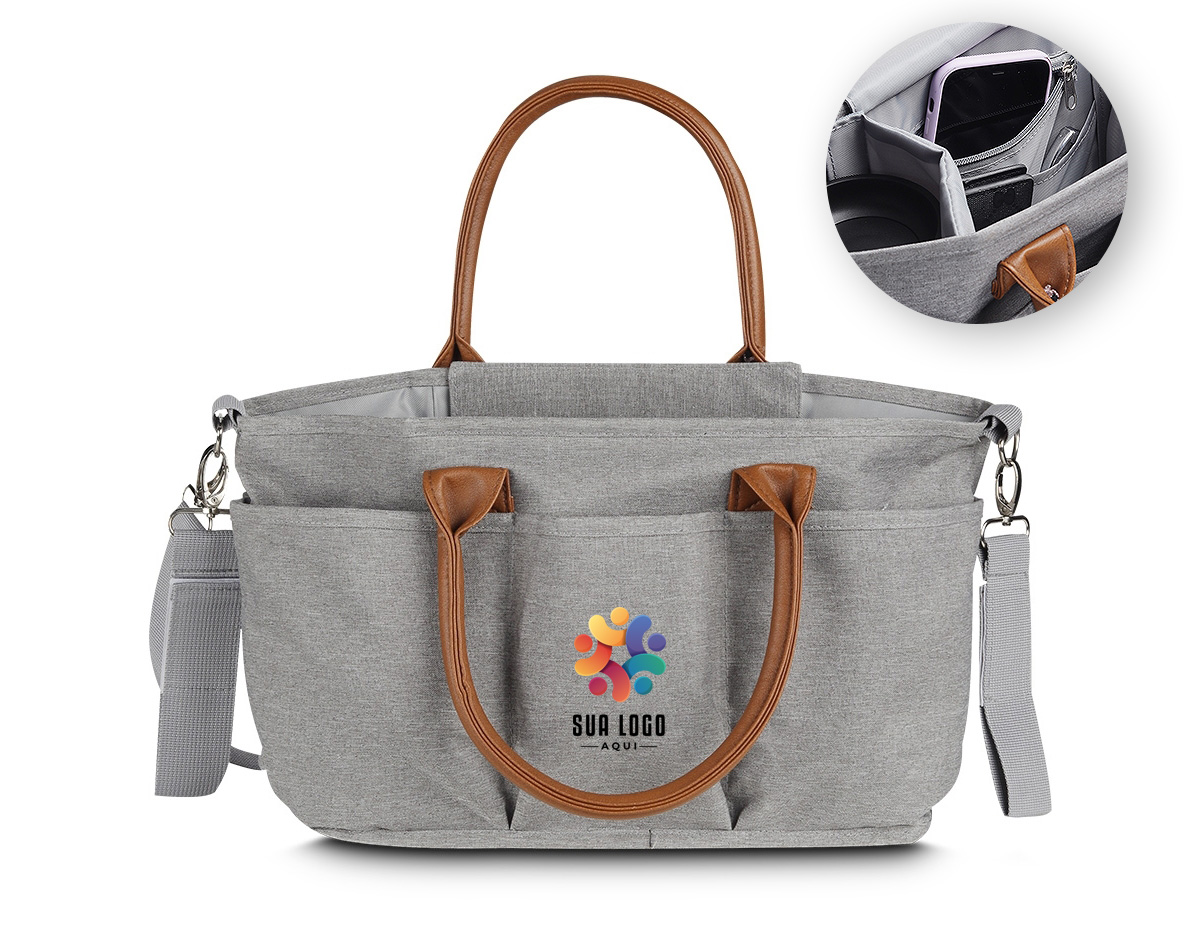 Nossa bolsa multifuncional de 8 litros é projetada para se adaptar a diferentes ocasiões. Produzida em poliéster com tecido resistente à água, possui alças em couro sintético que combinam com um design moderno e prático, ideal para guardar diversos itens, como os de bebê, trabalho e afins. A parte interna oferece um espaço amplo e adaptável, com duas divisórias contendo velcro que permitem criar até três compartimentos separados. Além disso, possui um bolso com zíper e três bolsos internos, sendo um deles com elástico para facilitar o acesso. O fechamento da bolsa é feito por um compartimento que protege a parte central. Para torná-la ainda mais funcional, conta com um compartimento térmico integrado, ajudando a manter a bebida na temperatura ideal por mais tempo. Na parte externa, há cinco bolsos adicionais, além de um engate de nylon com fechamento em velcro, perfeito para prender em carrinhos de bebê ou onde desejar. Suas alças podem ser usadas no ombro ou nas mãos. Além disso, conta com uma alça extra ajustável e removível, oferecendo mais versatilidade sempre que necessário. Essa bolsa é uma excelente opção de brinde, unindo modernidade e praticidade.