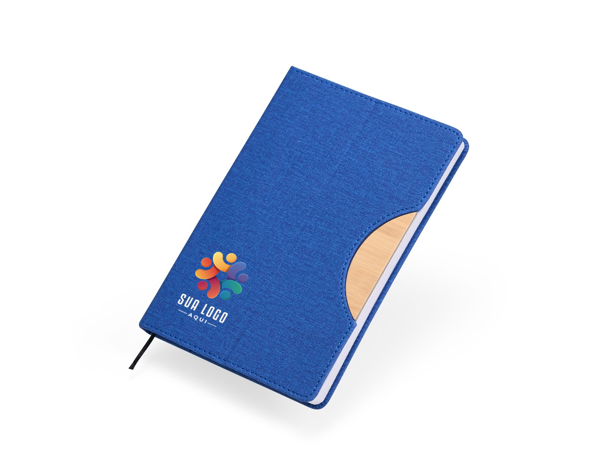 A nossa caderneta traz funcionalidade e estilo em um design leve e prático. Feita em rPET, com cerca de 96 folhas brancas pautadas, é perfeita para anotações, e conta com um suporte na capa feito de papelão, com revestimento similar ao bambu, ideal para manter o aparelho celular firme. A capa dobrável e flexível facilita o transporte, e o marcador de página em cetim agrega um toque de sofisticação.