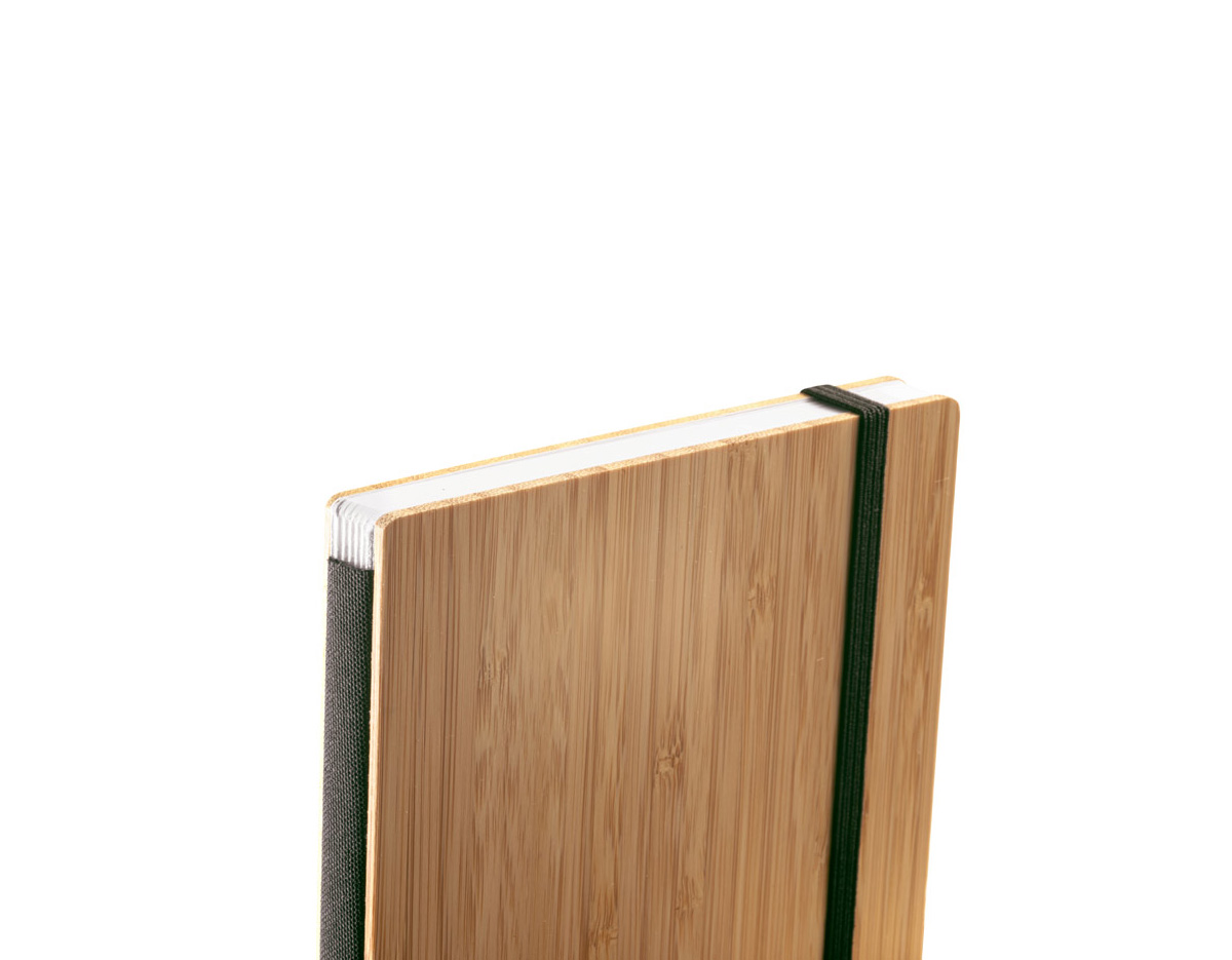 Caderno de bolso de capa e contracapa em placa de bambu e lombada em poliéster 100% reciclado (100% rPET). O interior contém 80 folhas lisas com papel reciclado, suporte para esferográfica (não inclusa) e elástico para fecho do caderno. A cor e o resultado da impressão nos materiais naturais pode variar entre produtos. 90 x 140 mm
