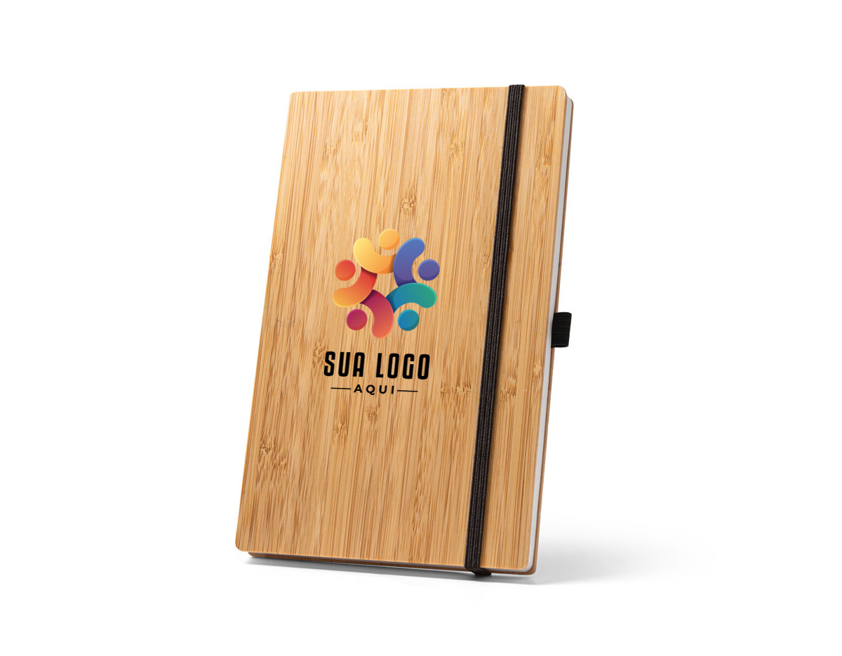 Caderno de bolso de capa e contracapa em placa de bambu e lombada em poliéster 100% reciclado (100% rPET). O interior contém 80 folhas lisas com papel reciclado, suporte para esferográfica (não inclusa) e elástico para fecho do caderno. A cor e o resultado da impressão nos materiais naturais pode variar entre produtos. 90 x 140 mm