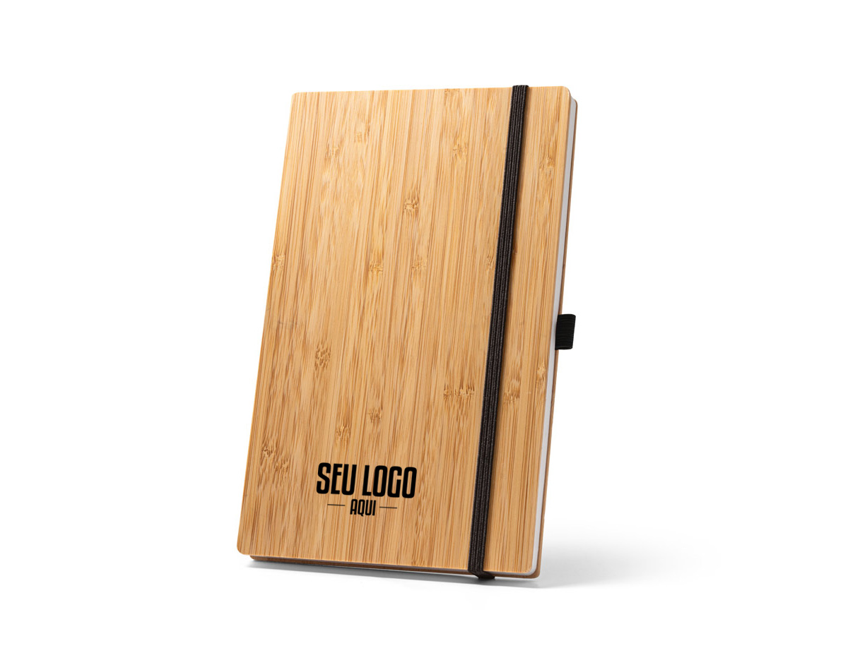 Caderno A5 de capa e contracapa em placa de bambu e lombada em poliéster 100% reciclado (100% rPET). O interior contém 96 folhas pautadas com papel reciclado, suporte para esferográfica (não inclusa) e elástico para fecho do caderno. A cor e o resultado da impressão nos materiais naturais pode variar entre produtos. 140 x 210 mm