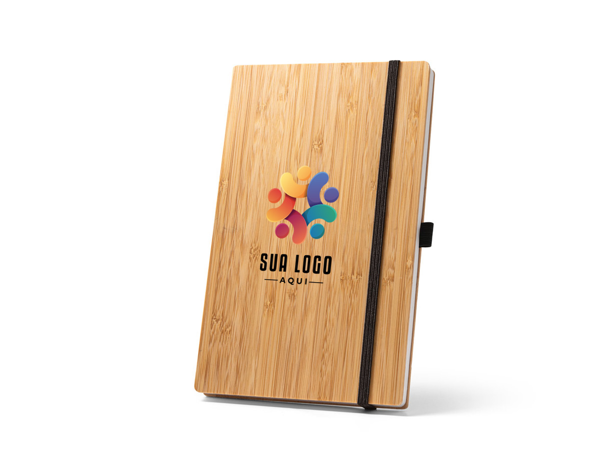 Caderno A5 de capa e contracapa em placa de bambu e lombada em poliéster 100% reciclado (100% rPET). O interior contém 96 folhas pautadas com papel reciclado, suporte para esferográfica (não inclusa) e elástico para fecho do caderno. A cor e o resultado da impressão nos materiais naturais pode variar entre produtos. 140 x 210 mm