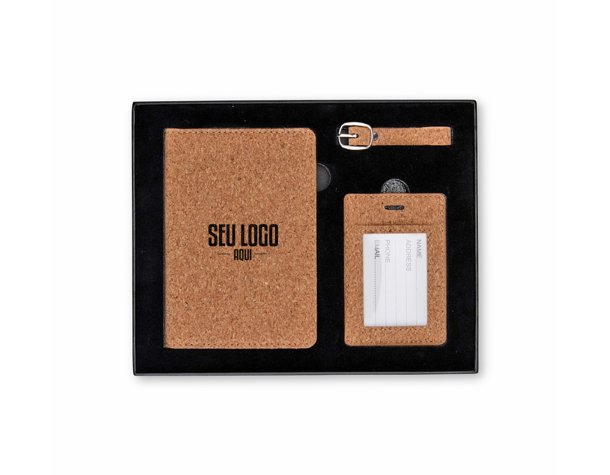 Kit viagem com 3 peças composto por porta-passaporte e tag identificadora de bagagem com alça, ambos com acabamento em cortiça. Acondicionado em estojo de papel com berço espumado e revestido em veludo, oferece praticidade e segurança na identificação de itens durante viagens.