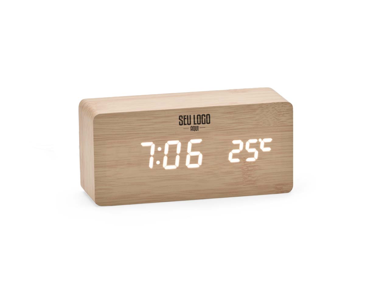 Relógio despertador de madeira com painel LED que exibe hora, data e temperatura. Permite programar até três alarmes com horários e frequências distintas. Funciona com 4 pilhas AAA (não inclusas) ou via cabo USB DC 5V (incluso). Une design elegante com funcionalidades práticas.