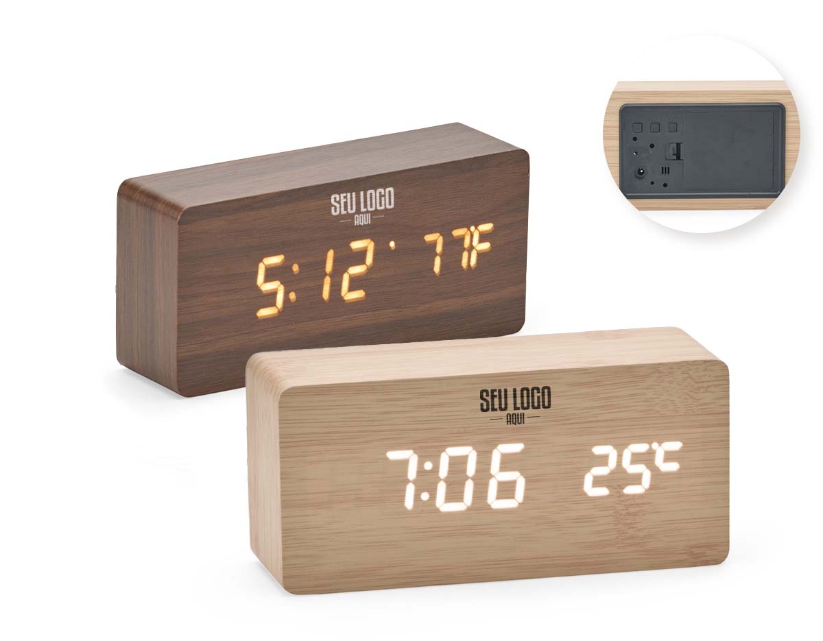 Relógio despertador de madeira com painel LED que exibe hora, data e temperatura. Permite programar até três alarmes com horários e frequências distintas. Funciona com 4 pilhas AAA (não inclusas) ou via cabo USB DC 5V (incluso). Une design elegante com funcionalidades práticas.