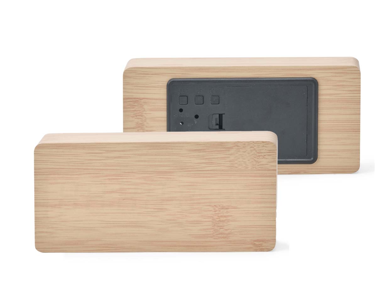 Relógio despertador de madeira com painel LED que exibe hora, data e temperatura. Permite programar até três alarmes com horários e frequências distintas. Funciona com 4 pilhas AAA (não inclusas) ou via cabo USB DC 5V (incluso). Une design elegante com funcionalidades práticas.