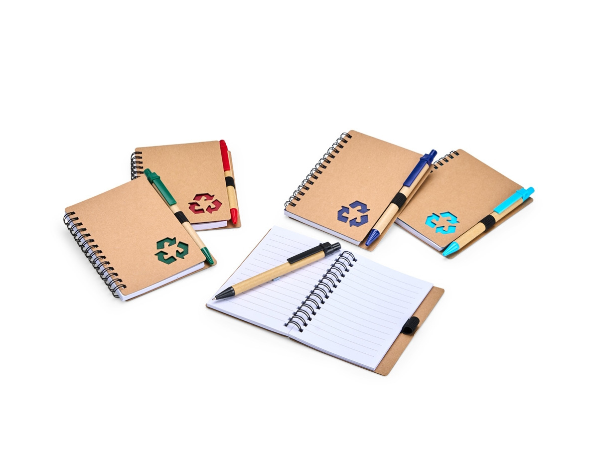 Caderno com capa de papelão e detalhe vazado em forma de símbolo de reciclagem. Possui encadernação Wire-O, cerca de 70 folhas pautadas brancas e elástico para caneta. Acompanha esferográfica azul (1,0 mm), com corpo em papelão, clique e ponteira plástica. Ideal para anotações diárias.
