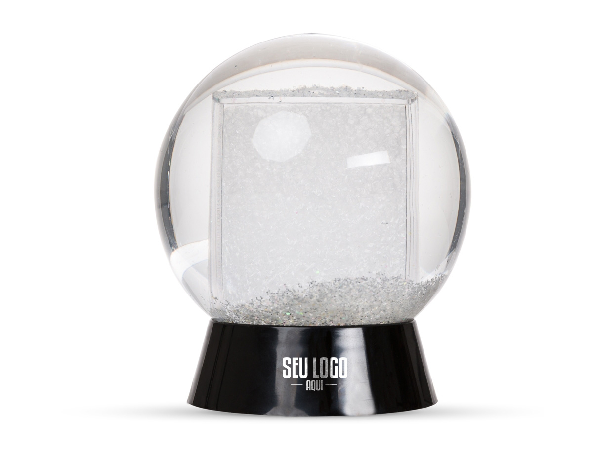 Globo de neve em plástico resistente, com glitter interno e porta-foto. A base preta é removível para inserção de uma foto no suporte interno, com dimensões de 8,5 cm x 4,7 cm, unindo decoração e funcionalidade em um só item.
