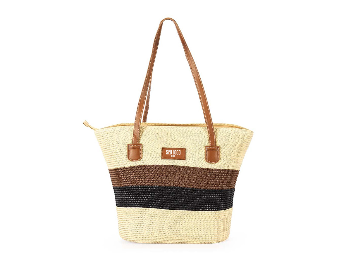 Bolsa feita em fios de papel torcido costurados com linha de nylon. Possui fechamento em zíper, compartimento interno com bolso compacto, alças e detalhes em couro sintético, incluindo plaquinha frontal costurada.