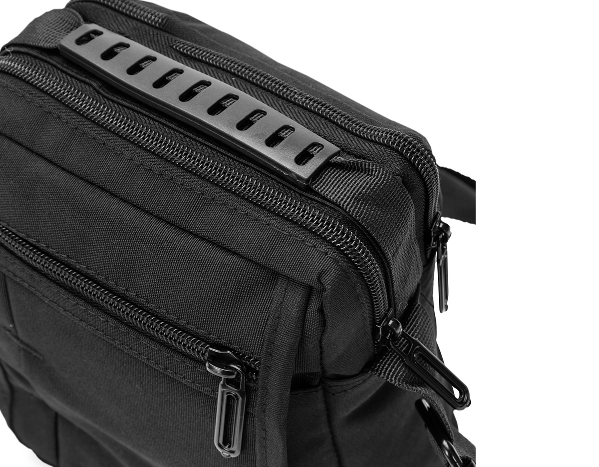 Bolsa de ombro confeccionada em nylon impermeável com alça ajustável para ombros e outra para mão. incluindo um bolso antifurto, um localizado na aba frontal, ambos com fechamento em zíper, e outro na parte interna da aba.