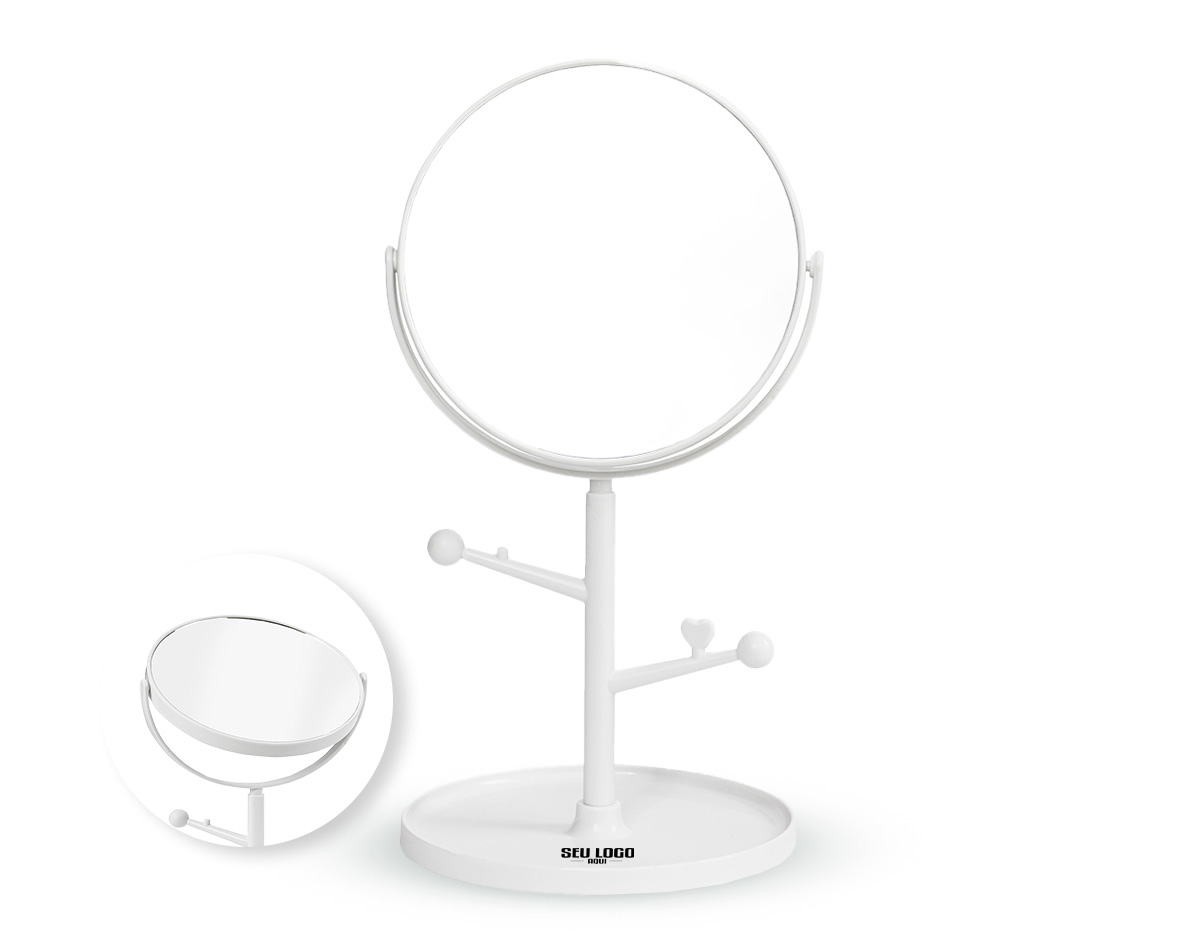 Espelho de mesa dupla face sem aumento. Possui estrutura em plástico com ganchos laterais e base circular para guardar pequenos objetos.